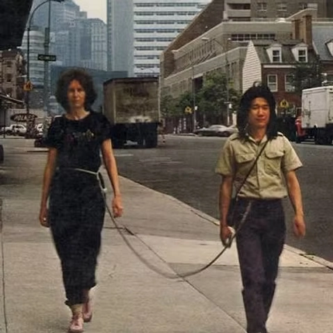 Artistas caminhando conectados por uma corda em performance artística urbana de arte contemporânea